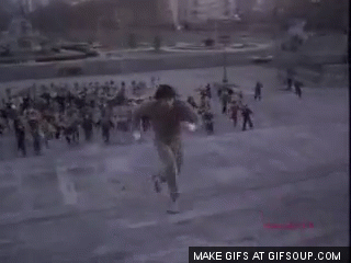 GIF de un hombre subiendo unas largas escaleras corriendo seguido por un grupo de personas