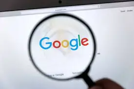 Lupa enfocando el logotipo de Google en una pantalla de resultados de búsqueda