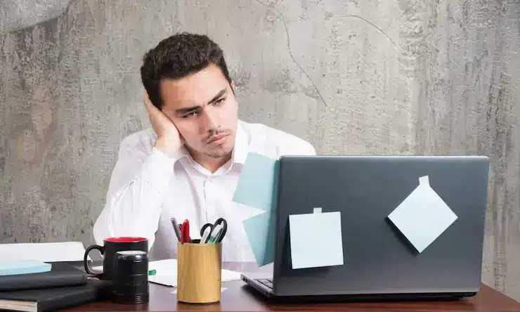 Emprendedor trabajando con el portátil emprendedor agobiado trabajando en su negocio online sin resultados claros